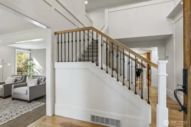 The 2 story foyer features art shelving and turned stairway with iron spindles.