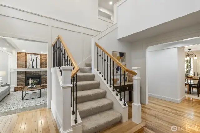 The 2 story foyer features art shelving and turned stairway with iron spindles.