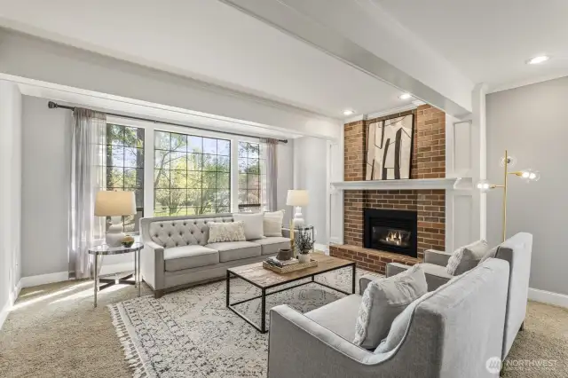 The formal living room boasts white painted beamed ceiling, crown molding and brick surround fireplace.