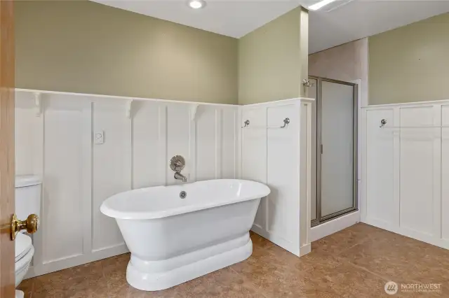 Primary bathroom with freestanding soaking tub and walk-in shower!  The wainscoting with picture rail adds character to the space!