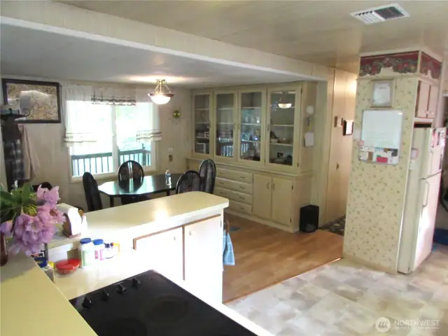 HARDWOOD FLOORING IN DINING ROOM AREA AND BUILT IN HUTCH FOR STORAGE, COVERED BACK DOOR ENTRY TO RIGHT OF FRIDGE (USED AS ACCESS FROM PARKING AREA.)