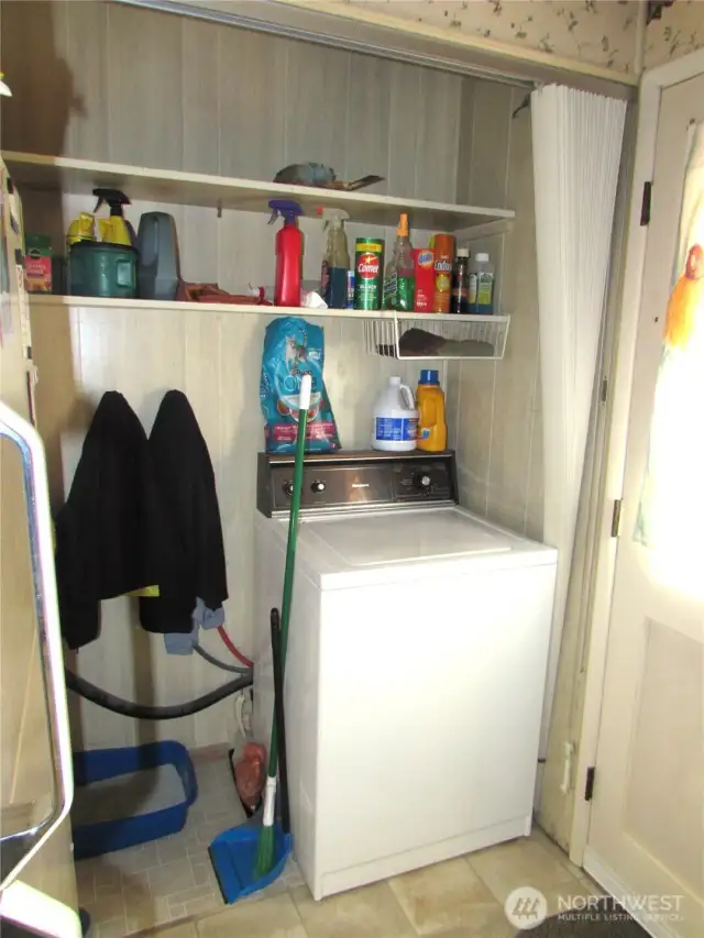 NEXT TO BACK DOOR IS WASHER MACHINE IN A ENCLOSED AREA WITH CURTAIN, DRYER IS A FEW STEPS AWAY.