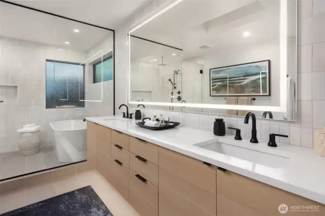 The spa-inspired ensuite bath offers a spacious wet room with dual showers and a soaking tub, heated floors, and an expansive walk-in closet with custom organizers and a discreet washer/dryer for ultimate convenience.