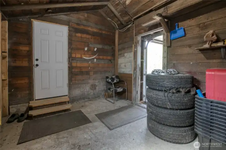 Unfinished, enclosed mud room which connects the garage door and back door of house