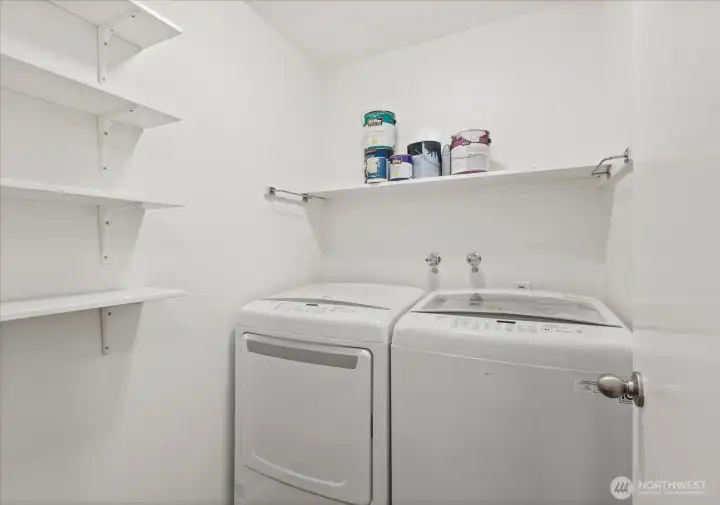 In-unit laundry room with storage shelves.