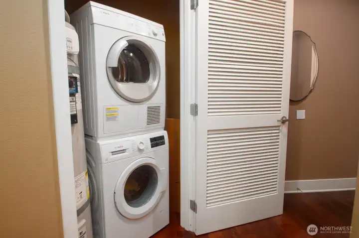 Utility closet near the unit entry houses a stacked washer and dryer, plus nearly new hot water tank.