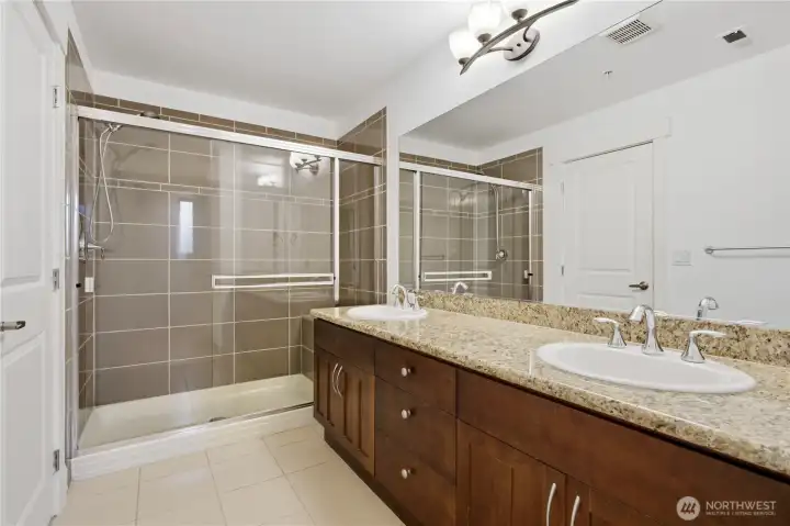 2nd bathroom with glass shower and double vanities
