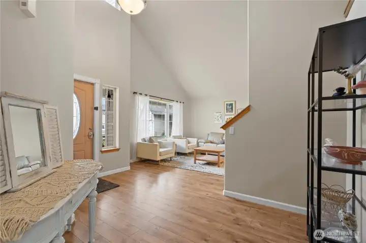 Step into a light-filled living space, where a welcoming foyer and soaring vaulted ceilings create an open, airy first impression.