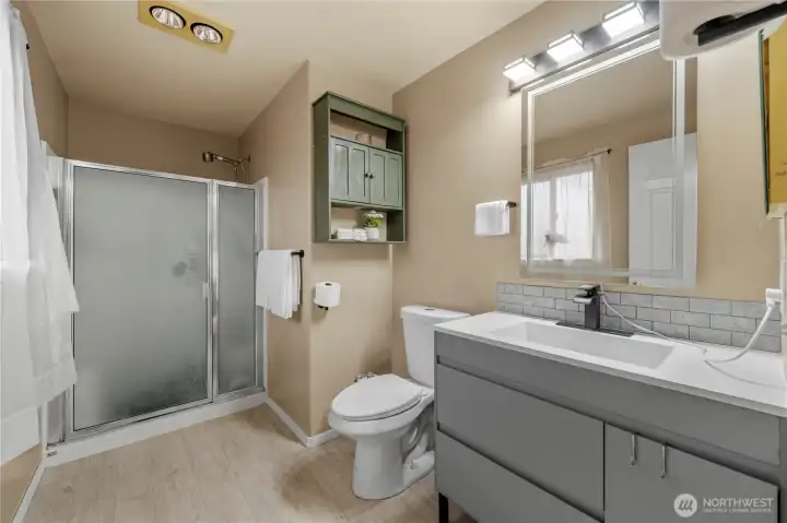 Primary bathroom, with updated vanity and flooring.