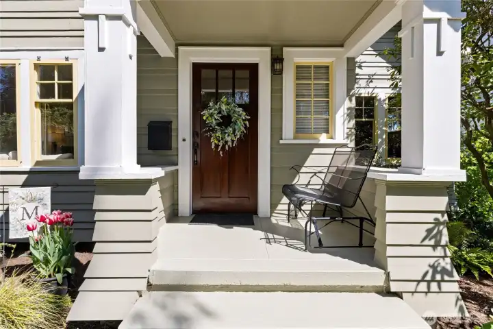 Covered Front porch with detailed millwork on the pillars & offset lap siding.