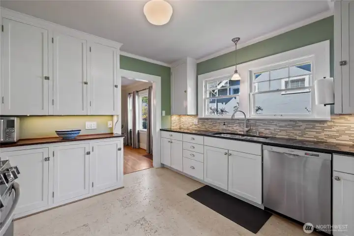 Double window over the sink with spacious counter, tile backsplash & great storage.