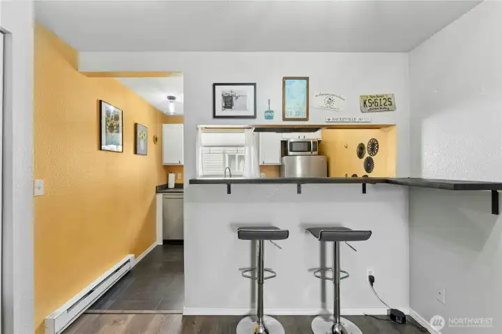A versatile dual-sided breakfast bar offers seating that faces both the kitchen and the living room, creating the perfect space for casual dining and entertaining.