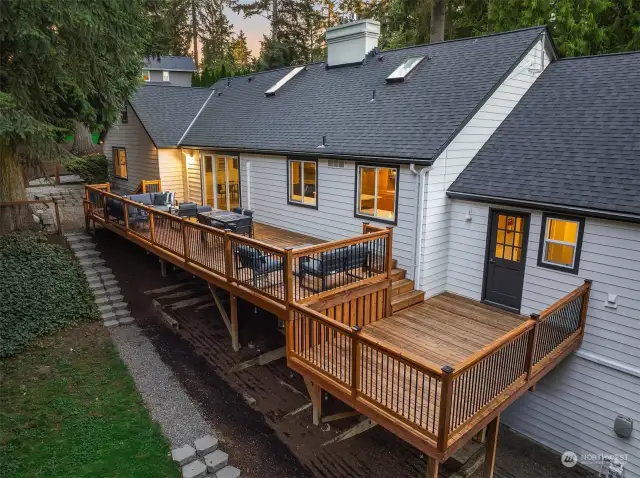 The freshly re-stained deck with Iron rails and caps is tiered, to offer multiple use opportunities. It runs the length of the home for entertaining or enjoying a quiet night outside.