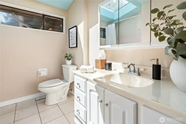 Main floor bathroom with skylight and laundry chute