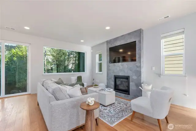 This spacious living room has new, large windows allowing perfect views to the private outdoor space all while allowing light to fill the space