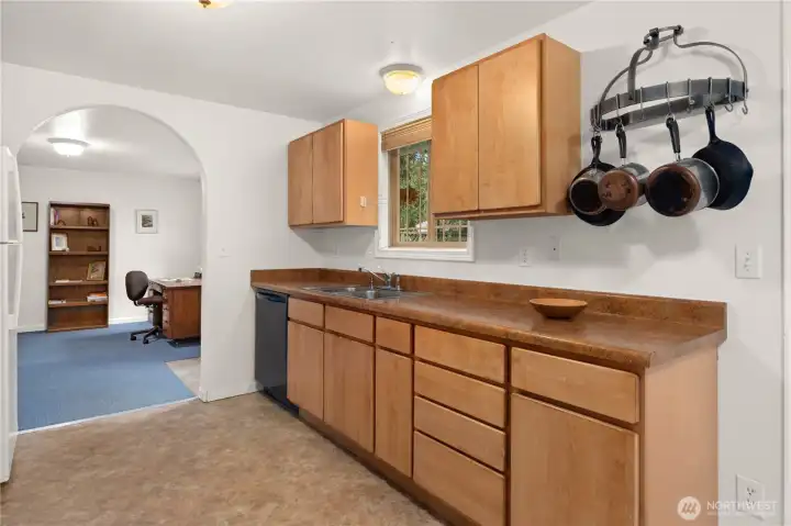 Kitchen counter has a deep two-compartment sink, garbage disposal and and a pot rack.