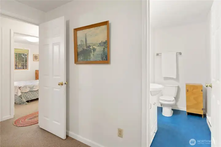 Primary half bath with a view to the 2nd bedroom.