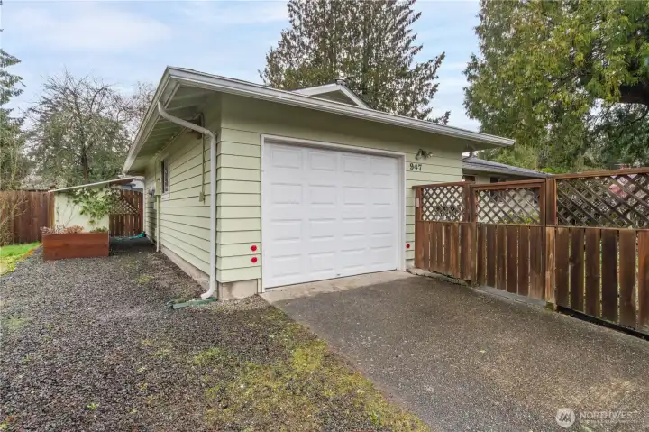 Side yard showing the garage door and fenced gate.