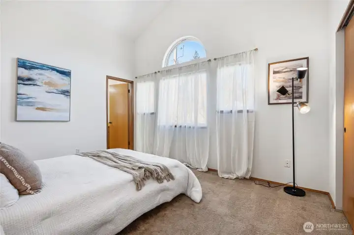 Second primary suite on the upper level has cathedral ceilings and a private en-suite.