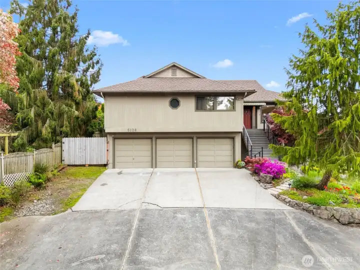 Three car garage and extra parking off the side.  The fence opens wide for easy access to the yard and storage.