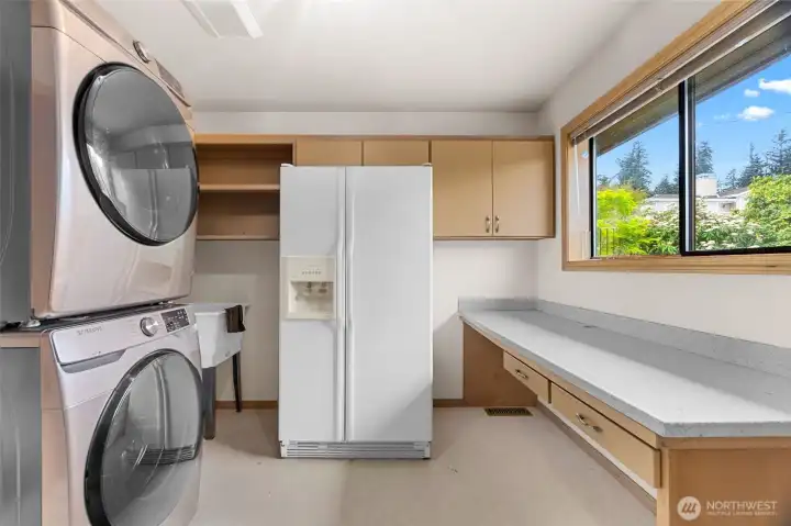 This laundry room is such a big asset to this home.  W/D stay, sink, second fridge space, and folding area.  There is a door that leads to the deck.