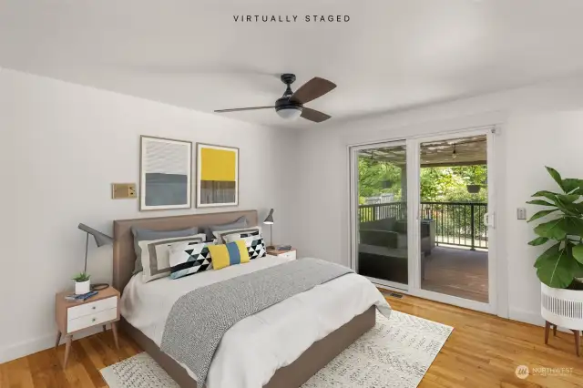 Primary bedroom with 3/4 bathroom, hardwood flooring, and a slider out to the deck.