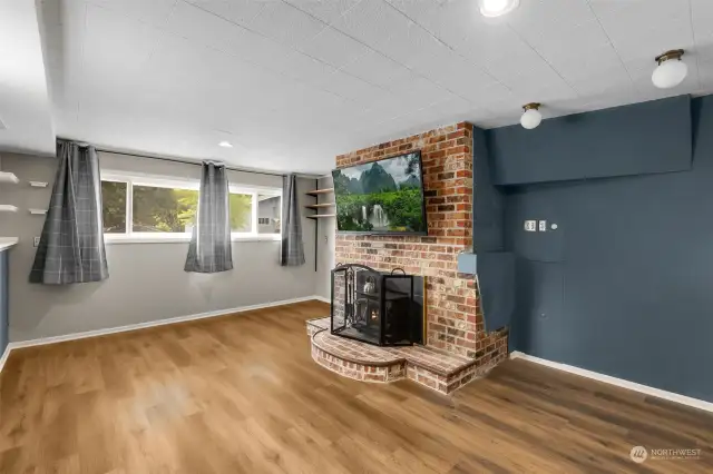 Living room with fireplace, fresh paint, and new LVP flooring.