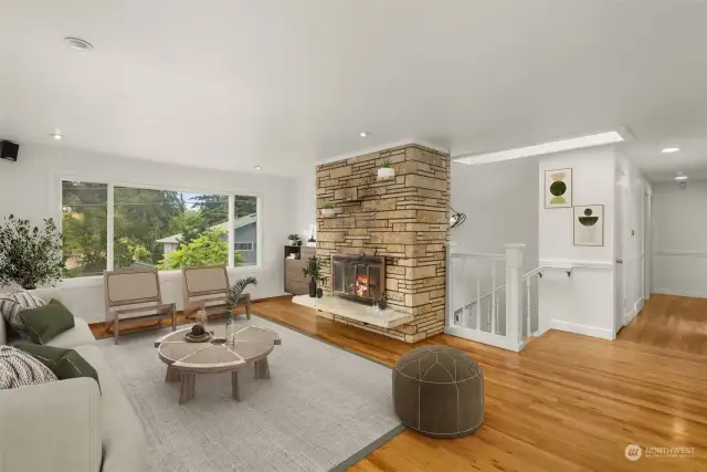 Family room with hardwood flooring, fresh paint, fireplace, and a view.