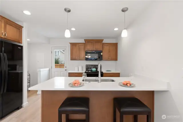 Informal dining at the slab granite countertop which is extended to provide seating