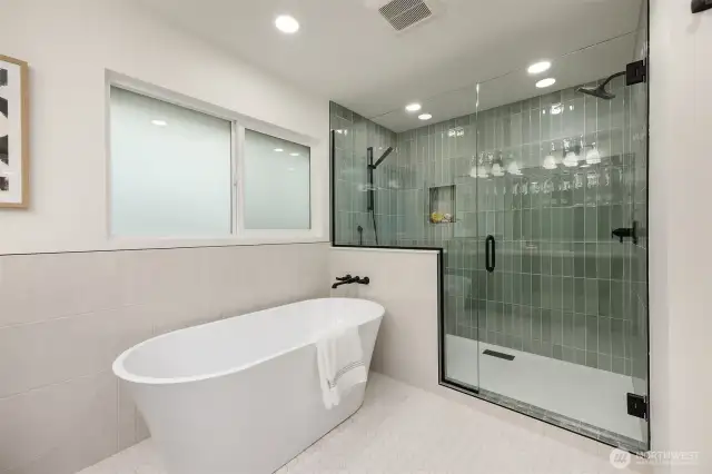 Beautiful seafoam green tiles line this expansive dual-shower.
