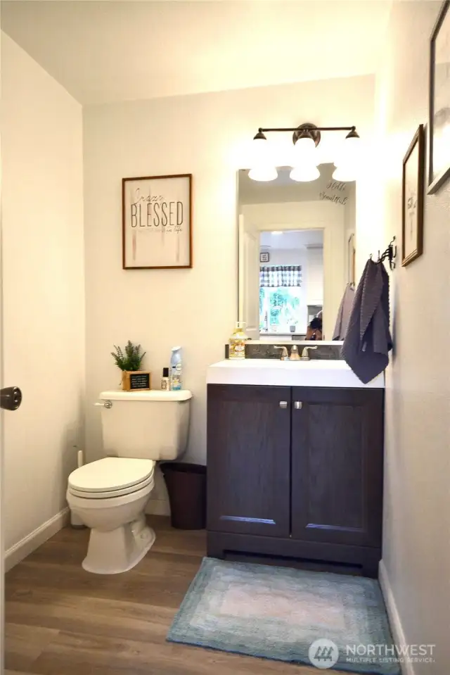 1/2 bathroom for guest has new vanity, new LVP flooring, new lighting.