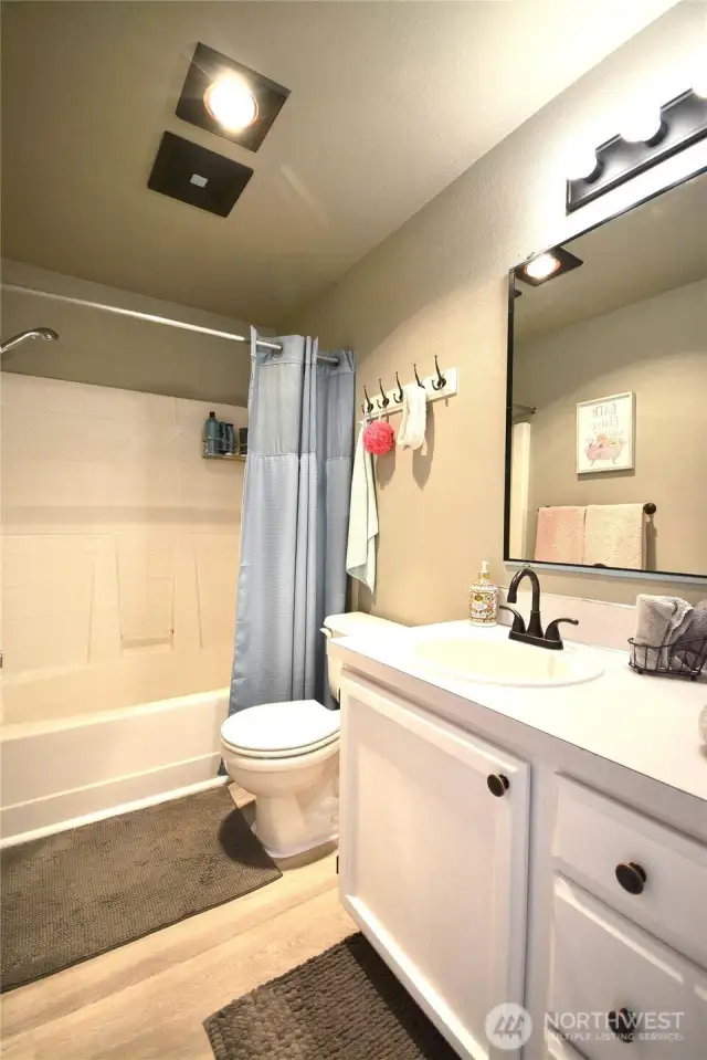 Guest bathroom has a combo tub/shower new LVP flooring.