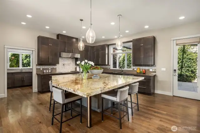 The chef’s kitchen is a culinary showpiece, boasting an oversized island, premium appliances, and an adjoining catering kitchen with a walk-in pantry, making hosting effortless and memorable.