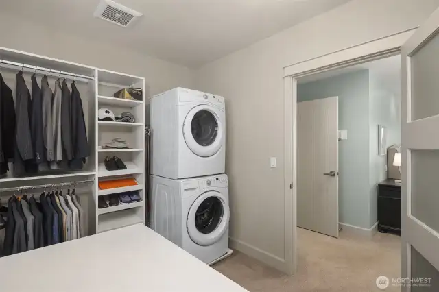Spacious primary closet with dedicated washer and dryer.