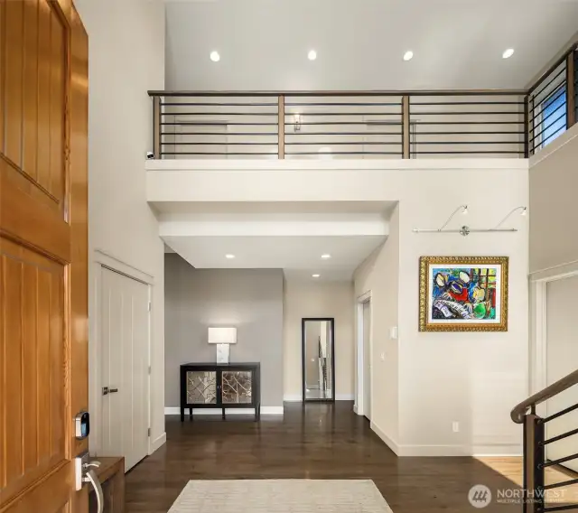 Step through a dramatic entry into the spacious great room, where a custom-brushed metal fireplace serves as a striking artistic centerpiece.