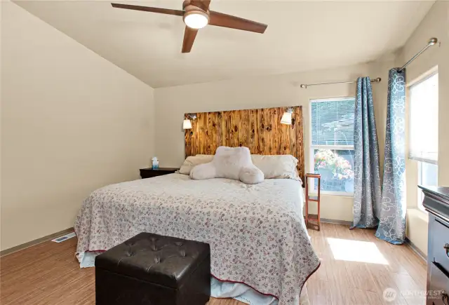 The spacious primary bedroom is filled with natural light and offers a peaceful view of the garden, creating a serene retreat to begin and end your day.