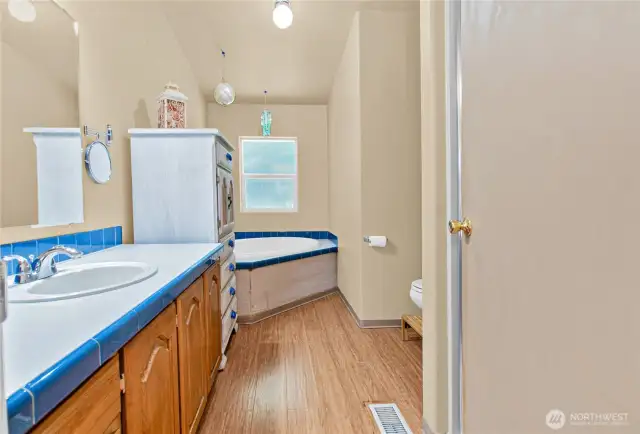 The primary bath features a lovely soaking tub for relaxing evenings, along with a spacious walk-in shower for everyday convenience and comfort.