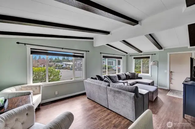 Living room has vaulted ceiling with beams