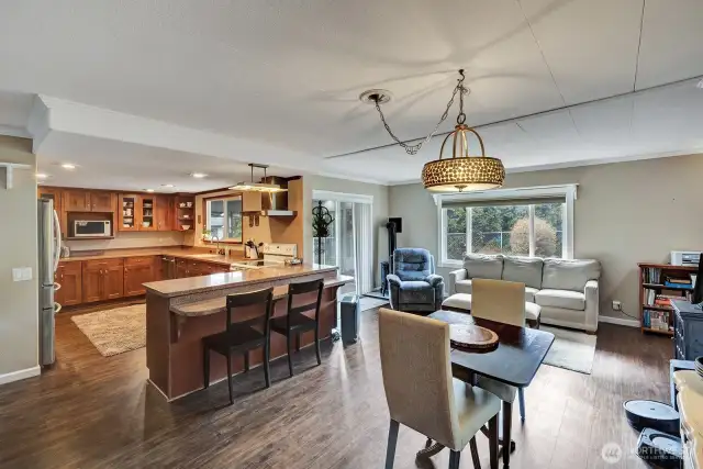 View of breakfast area, kitchen eating bar, family room & sliding door to sunroom