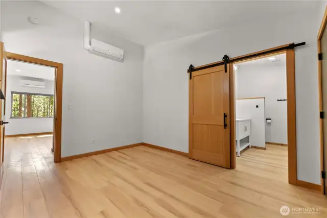 Primary bedroom on main floor with access to dining area and ensuite bathroom seen in this photo.