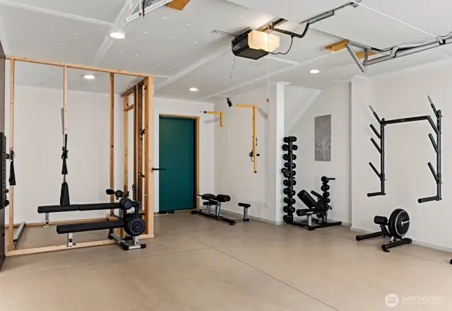 One car garage with pre-framed sauna space.  Wired for an electric sauna heater. Home gym equipment is virtually staged.