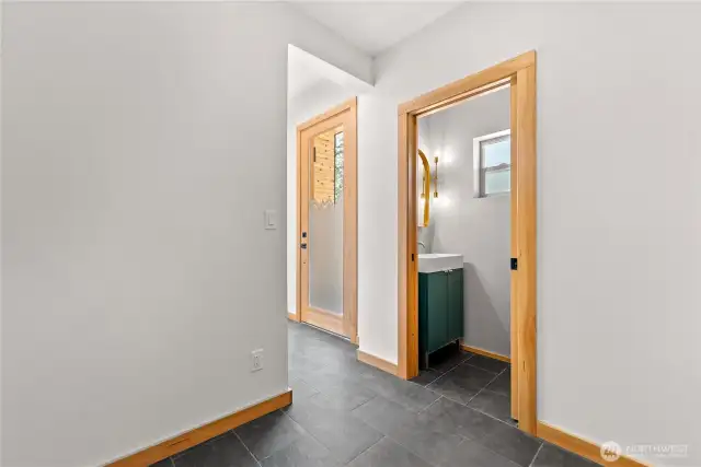 Practical entry way into main home with half bath.