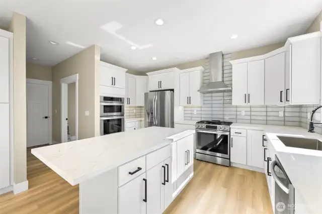 This kitchen boasts a stove/oven with a grill on top and a wall oven and microwave.