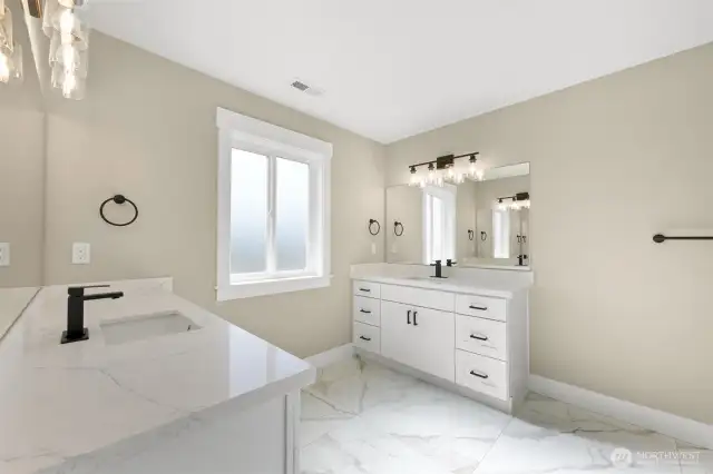 The primary bedroom has duel vanities with marble flooring and quartz countertops.