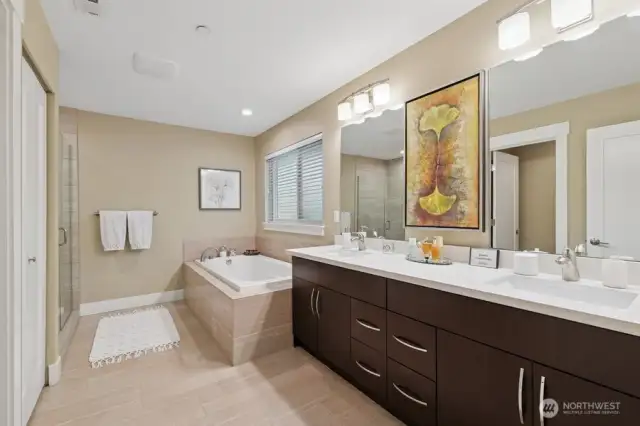 Custom primary bath with large soaking tub, 2 sinks and tile shower with glass doors.