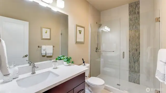Main floor 3/4 bath with newer custom tile shower, quarts countertop & tile flooring.