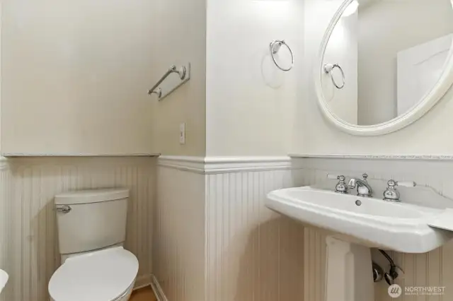 The main-level powder room is perfect for guests, offering convenience and style with a thoughtfully designed space just off the main living areas.