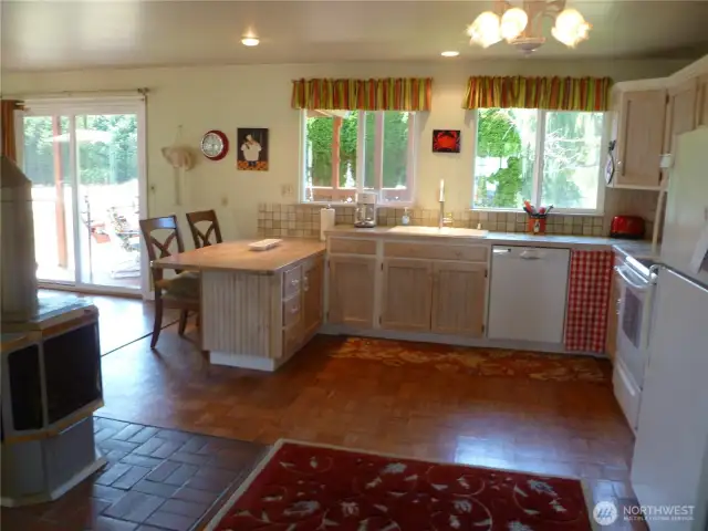 Sunny farmhouse-style kitchen.  Note pellet stove, one of several heating types.