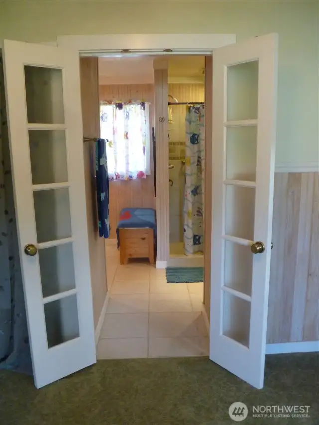 Tiny french doors lead to primary bath.
