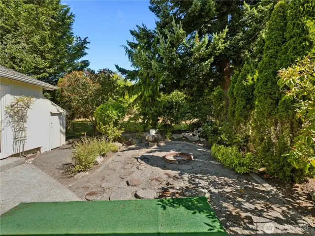 Back yard with fire pit for summer fun.  Guest studio on right.